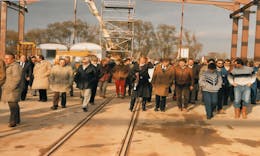 A large crowd of people walking across a construction site