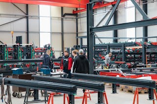 Rundgang bei MINDA Mehrere Leute stehen in der Produktionshalle von MINDA