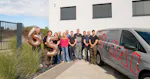 The photo shows HOWIAL employees holding a ‘65’ in their hands in front of their company building.