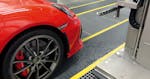 Die rote Front eines Autos von der Seite, was noch in einer Fertigungsanlage steht